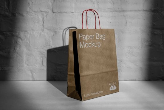 Paper bag mockup on a white table against a textured wall, ideal for branding presentations and packaging designs for designers.